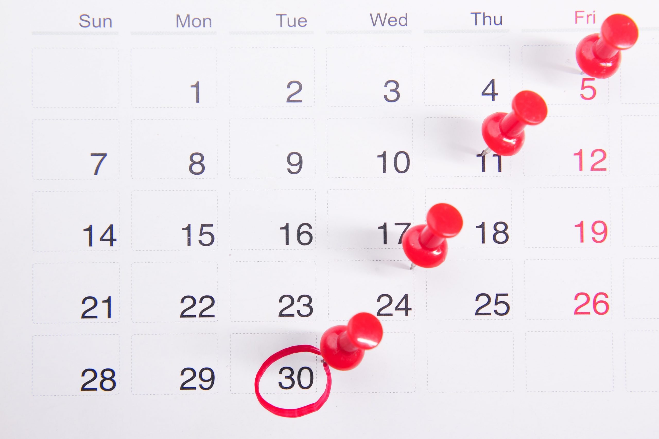 Calendar with push pins and circled moving date showing scheduling challenges